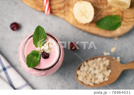 Homemade yogurt smoothie with banana, cranberry and oatmeal, top view, flat lay 76964031