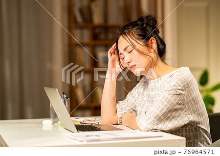 テレワークの残業で疲れる若い女性 テレワークの残業で疲れる若い女性 76964571