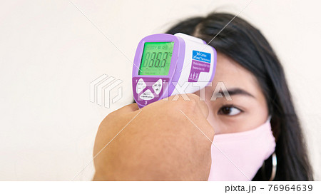 Measure temperature with infrared thermometer 76964639
