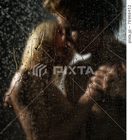 Young nude couple in shower above glass with drops Young nude couple in shower above glass with drops 76966452