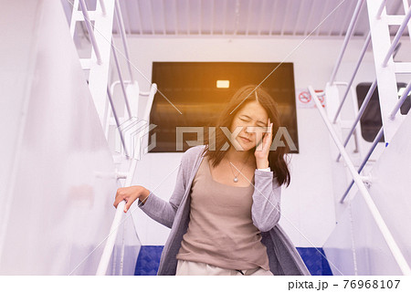 Woman suffering from sea sickness and feeling headache while on boat 76968107