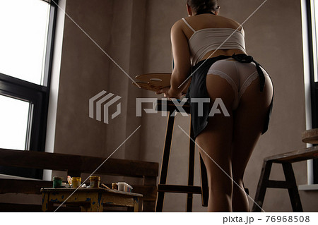 Woman in lingerie painting picture in art studio Woman in lingerie painting picture in art studio 76968508