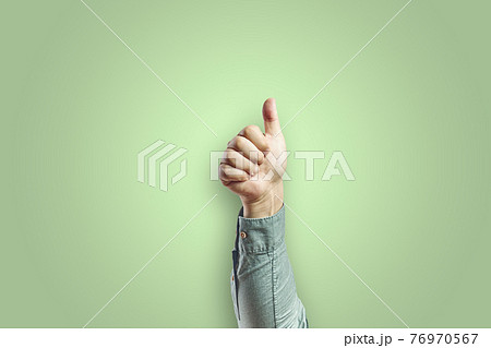 Man arm making ok gesture with hand isolated on green background Man arm making ok gesture with hand isolated on green background 76970567