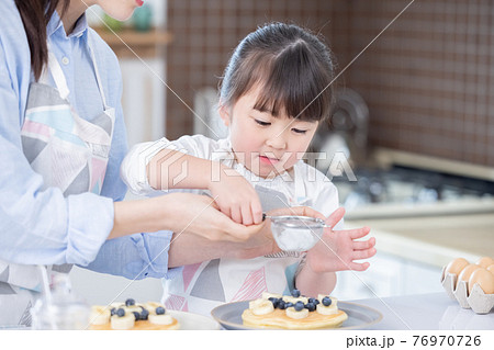 ファミリー　ホットケーキ作りを楽しむ女の子 76970726