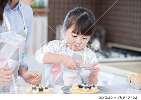 ファミリー　ホットケーキ作りを楽しむ女の子 76970762