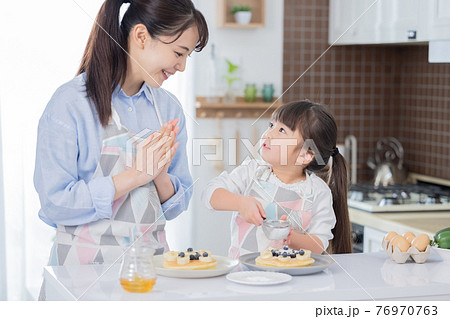 ファミリー　ホットケーキ作りを楽しむ女の子 76970763