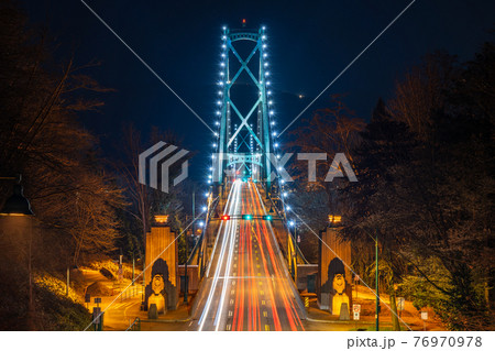 Lions Gate Bridge at night. Cars driving on the bridge with long exposure. Stanley Park, Vancouver, British Colombia, Canada. Lions Gate Bridge at night. Cars driving on the bridge with long exposure. Stanley Park, Vancouver, British Colombia, Canada. 76970978