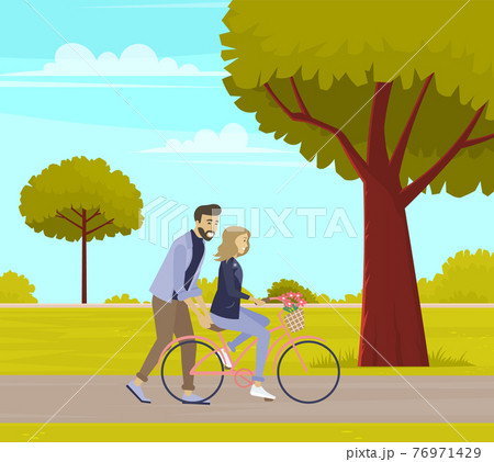 Guy teaches his friend to ride bike. Man supports woman on bicycle on date. People rest in nature 76971429