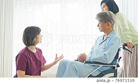 看護師の説明を聞く患者と家族 76971510