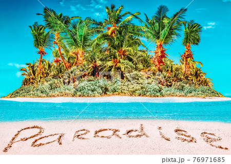 Whole tropical island within atoll in tropical Ocean and inscription "Paradise" in the sand on a tropical island. 76971685