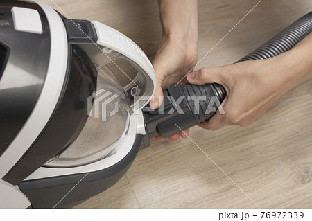 woman woman takes apart modern cyclone bagless vacuum cleaner. housekeeping, cleaning woman woman takes apart modern cyclone bagless vacuum cleaner. housekeeping, cleaning 76972339