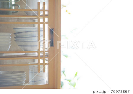 朝日の差し込む部屋、和食器が収納された食器棚 76972867