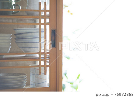 朝日の差し込む部屋、和食器が収納された食器棚 76972868