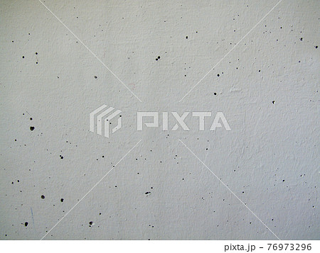 Close-up background texture of a painted white concrete wall with holes 76973296