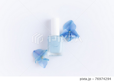 Blue petals with nail polish in transparent glass bottle, white background 76974294