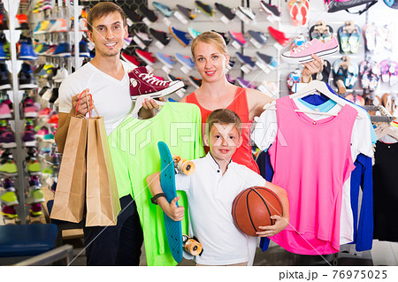 Mature parents with boy in sport store Mature parents with boy in sport store 76975025