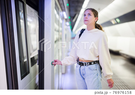 Portrait of a girl in the subway, about to enter the train car Portrait of a girl in the subway, about to enter the train car 76976158