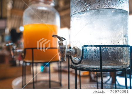 Orange juice and water in a glass jar 76976391