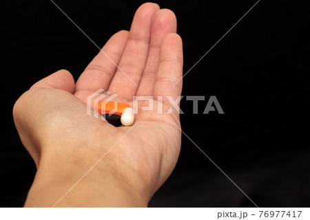 Pills on palm closeup on gray background Pills on palm closeup on gray background 76977417