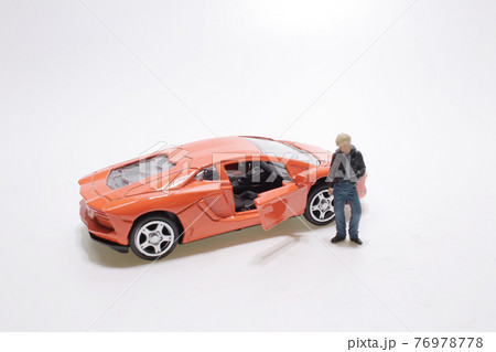 a mini Guy near the orange sport car 76978778