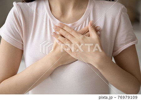 Grateful young woman applying hands on chest, expressing love Grateful young woman applying hands on chest, expressing love 76979109