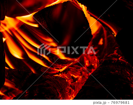 Burning firewood in rural oven. Red flame of wood stove in the dark. Cozy warm fireplace bonfire combustion at night. 76979681
