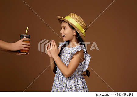 someone gives glass of orange juice to cute little girl someone gives glass of orange juice to cute little girl 76979691