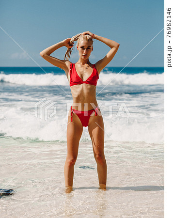 Attractive slim woman in bikini relax at beach in Bali. Caucasian model with ocean Attractive slim woman in bikini relax at beach in Bali. Caucasian model with ocean 76982146