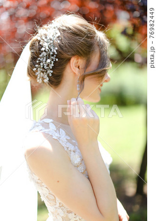Back view portrait of bride wearing transparent veil and white dress. Back view portrait of bride wearing transparent veil and white dress. 76982449