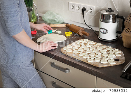 Portrait young adult brunette caucasian woman making dough with roller pin for sweet tasty homemade cookies at home kitchen. Female person housewife mother cooking delicoius healthy handmade pastry Portrait young adult brunette caucasian woman making dough with roller pin for sweet tasty homemade cookies at home kitchen. Female person housewife mother cooking delicoius healthy handmade pastry 76983552