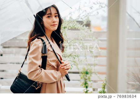 雨が降る中出勤する若い女性 雨が降る中出勤する若い女性 76983634