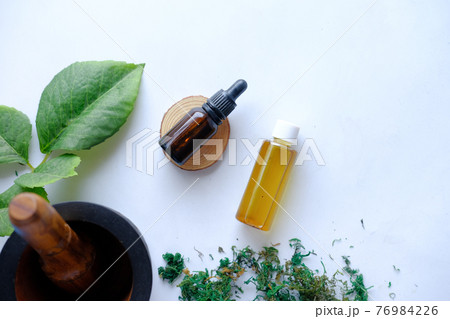eucalyptus essential oils in a glass bottle with green leaf on white background 76984226