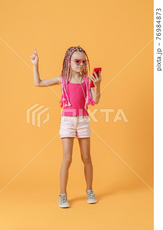 Beautiful European girl with dreadlocks. Mobile phone in the han 76984873