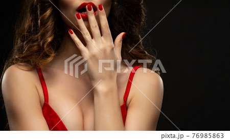 Beautiful girl showing red manicure nails . makeup and cosmetics. Brunette girl with long and shiny curly hair 76985863