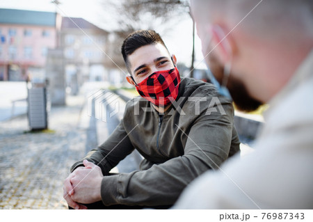 Men friends outdoors on street in town talking, coronavirus and new normal concept. 76987343