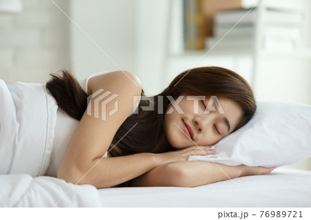 Beautiful Attractive Asian woman sleep and sweet dream lying on bed in cozy bedroom in the morning feeling so relax and comfortable,Healthcare Concept 76989721