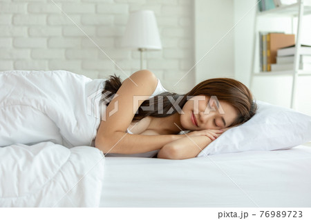 Beautiful Attractive Asian woman sleep and sweet dream lying on bed in cozy bedroom in the morning feeling so relax and comfortable,Healthcare Concept 76989723