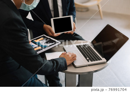 Businessmen team or financial data analysts working with tablets and laptop computers and data graphs. Plan to analyzing projects in the office. Businessmen team or financial data analysts working with tablets and laptop computers and data graphs. Plan to analyzing projects in the office. 76991704