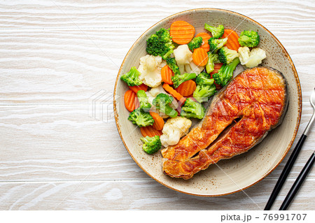 Grilled salmon steak with vegetables salad from above copy space Grilled salmon steak with vegetables salad from above copy space 76991707