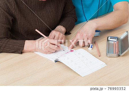 勉強するシニアと介護スタッフ 76993352