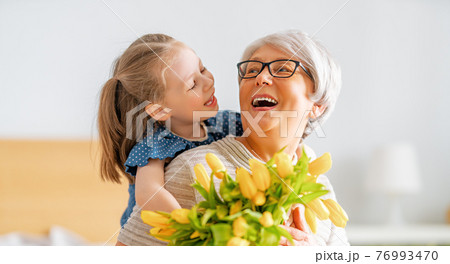 Grandma and girl smiling and hugging Grandma and girl smiling and hugging 76993470