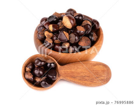 Guarana seed in wooden bowl and spoon, isolated on white background. Dietary supplement guarana, caffeine cource for energy drinks. Guarana seed in wooden bowl and spoon, isolated on white background. Dietary supplement guarana, caffeine cource for energy drinks. 76995886