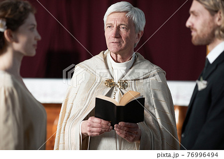 Priest marrying the couple Priest marrying the couple 76996494