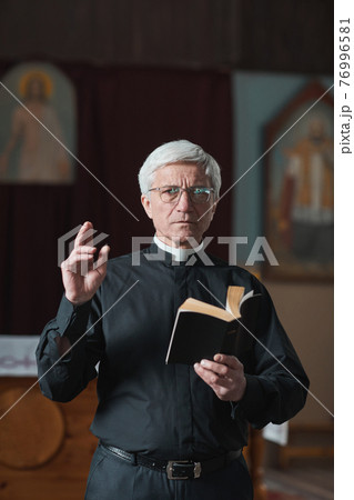 Senior priest reading the Bible Senior priest reading the Bible 76996581