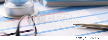 Glasses and hourglass are on calendar in office closeup Glasses and hourglass are on calendar in office closeup 76997939