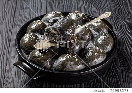 Black buns with sea salt on top, close-up Black buns with sea salt on top, close-up 76998573