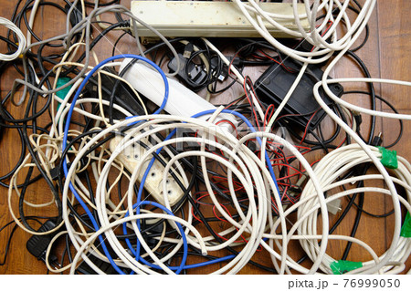A tangled tangle of unnecessary wires lies on the floor A tangled tangle of unnecessary wires lies on the floor 76999050