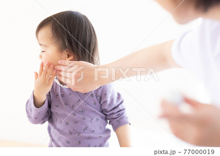 子供に保湿クリームをつけるママ 77000019