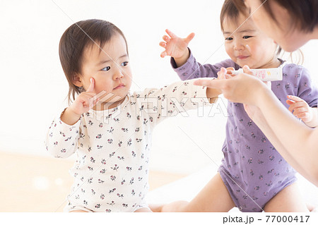 保湿クリームをつけるママと幼児 77000417
