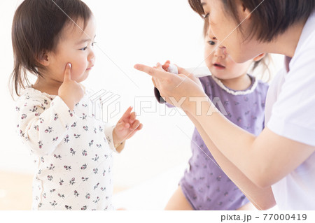 保湿クリームをつけるママと幼児 77000419